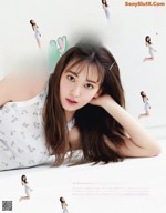 Sakura Miyawaki 宮脇咲良, Maquia Magazine 2021.10 A woman laying on the ground with her hands on her head.