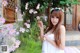 A woman in a white dress holding a bunch of flowers.