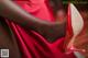 A close up of a woman's legs wearing red high heels.