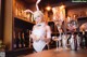 A woman in a bunny costume standing behind a bar.