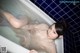 A woman laying in a bathtub with water on her body.